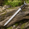 Celtic War Sword with polished stainless steel blade displayed on a moss-covered log.