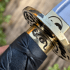 Yin Yang Katana with polished steel blade, black wrapped handle, gold-tone Yin Yang guard, and matching black scabbard.