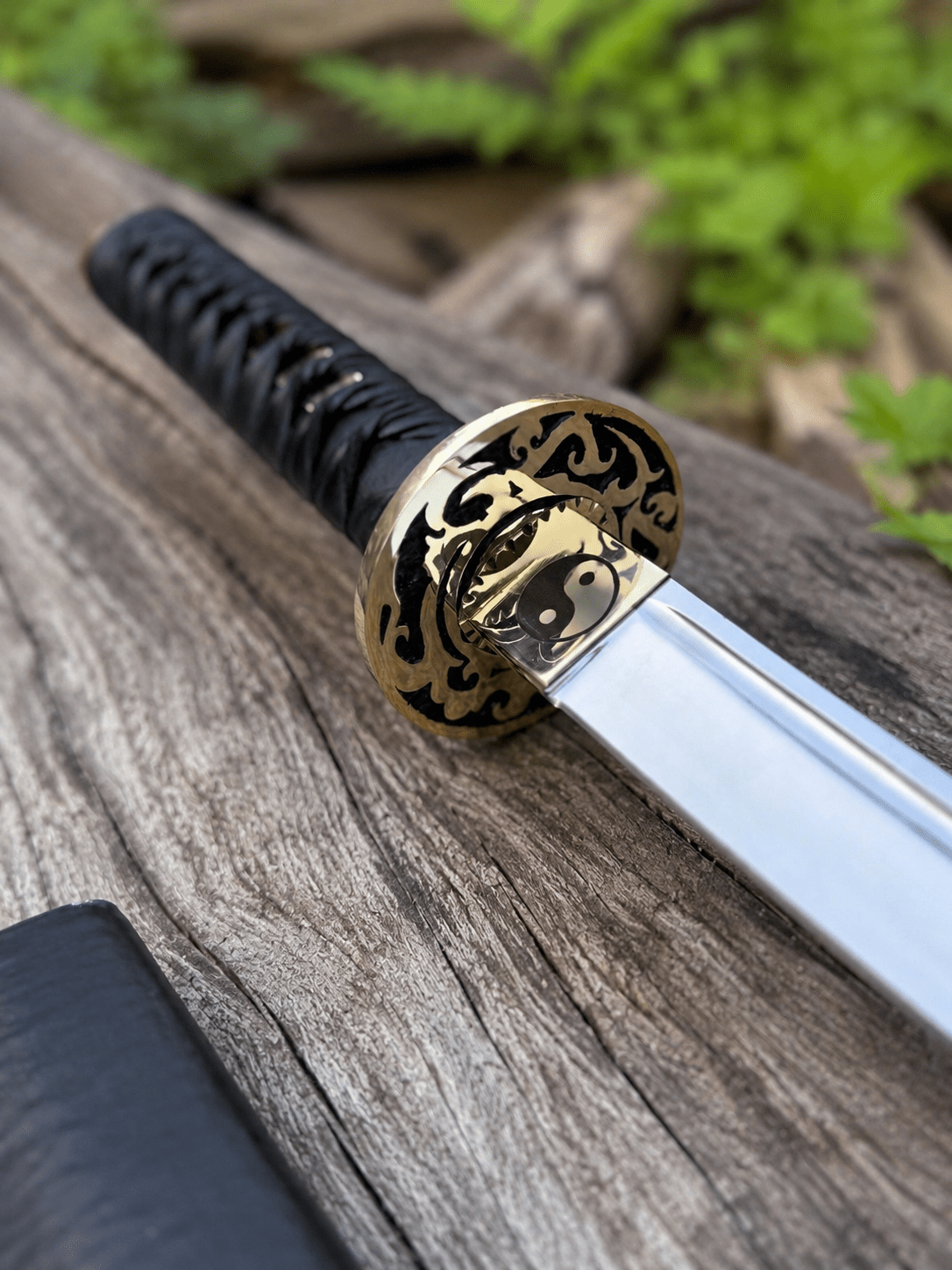 Yin Yang Katana with polished steel blade, black wrapped handle, gold-tone Yin Yang guard, and matching black scabbard.